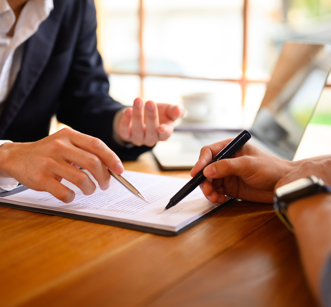 Two people discussing documents at table.